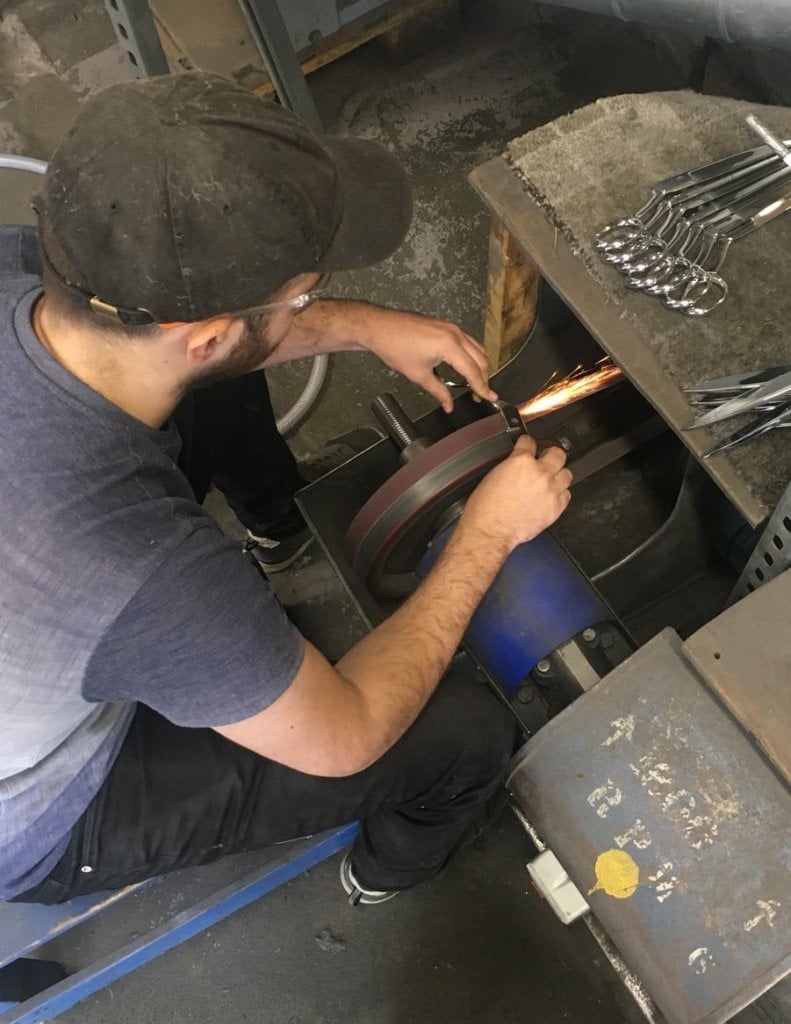 A young putter grinding a scissor blade at the Kutrite Works bench