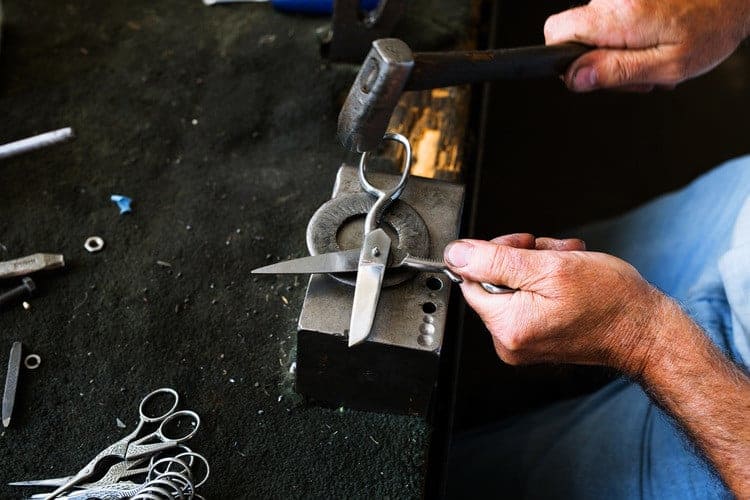 An Ernest Wright putter-togetherer hammering the curve into a blade, sparks flying